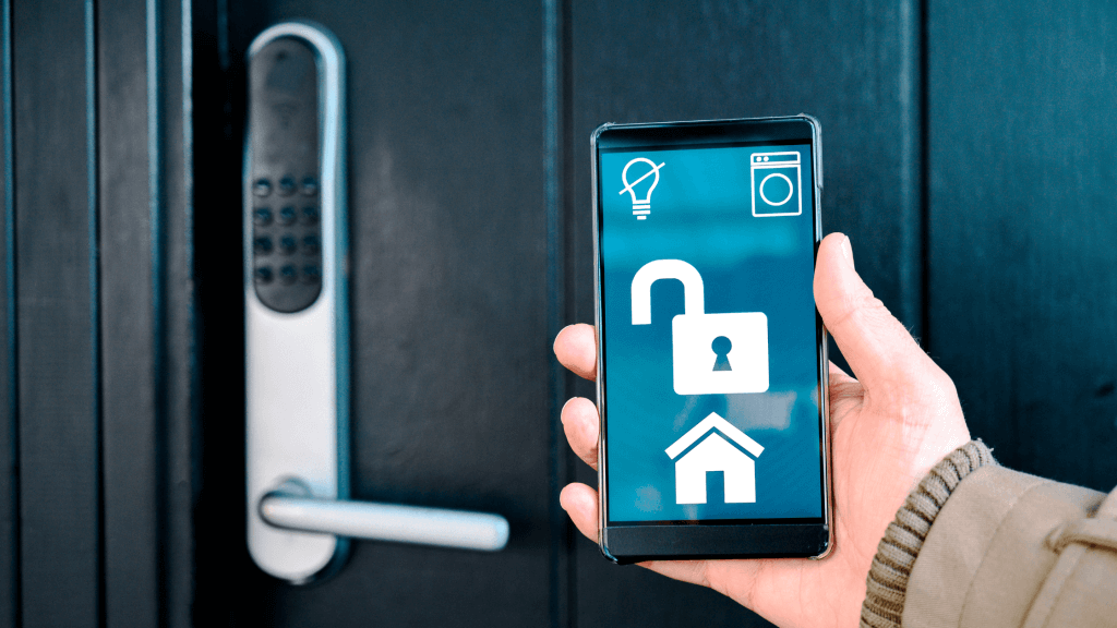 Image showing a hand holding a mobile phone with a smart lock app open, controlling a door lock in the backdrop